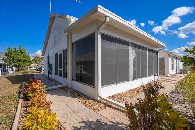 10444 S Clint Loop, Floral City, FL 34436 - view of property exterior with a sunroom, stucco siding, a patio, and central air condition unit