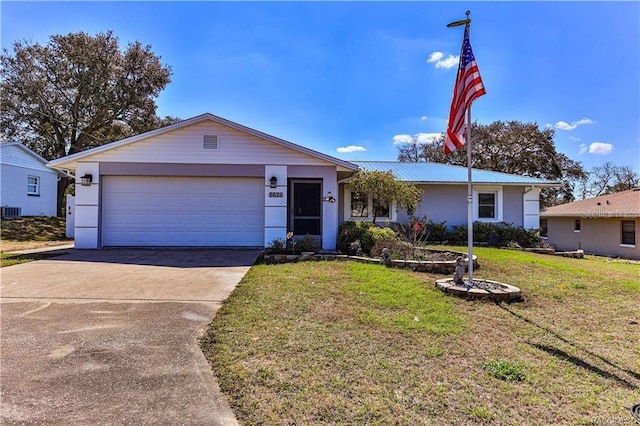 5626 W Justin Ct, Homosassa, FL 34448 - ranch-style home featuring a front lawn, concrete driveway, stucco siding, an attached garage, and metal roof