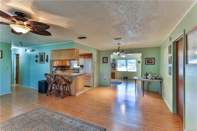 5626 W Justin Ct, Homosassa, FL 34448 - kitchen featuring fridge with ice dispenser, light wood-type flooring, a breakfast bar area, a chandelier, and a peninsula
