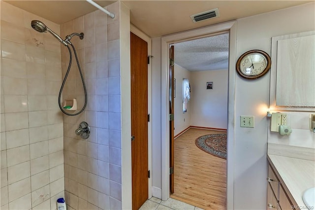 5626 W Justin Ct, Homosassa, FL 34448 - bathroom featuring tiled shower, vanity, and a textured ceiling