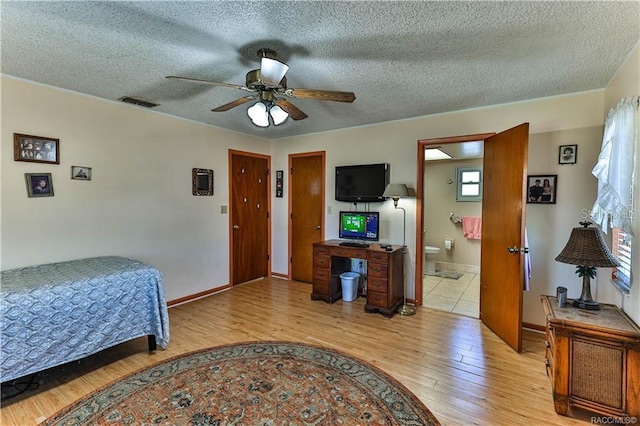 5626 W Justin Ct, Homosassa, FL 34448 - bedroom featuring light wood-style floors, a textured ceiling, baseboards, a ceiling fan, and ensuite bath