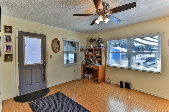5626 W Justin Ct, Homosassa, FL 34448 - entrance foyer with a textured ceiling, ceiling fan, plenty of natural light, light wood-style flooring, and baseboards