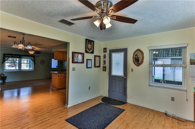5626 W Justin Ct, Homosassa, FL 34448 - entryway featuring light wood finished floors, ceiling fan, a chandelier, a textured ceiling, and baseboards