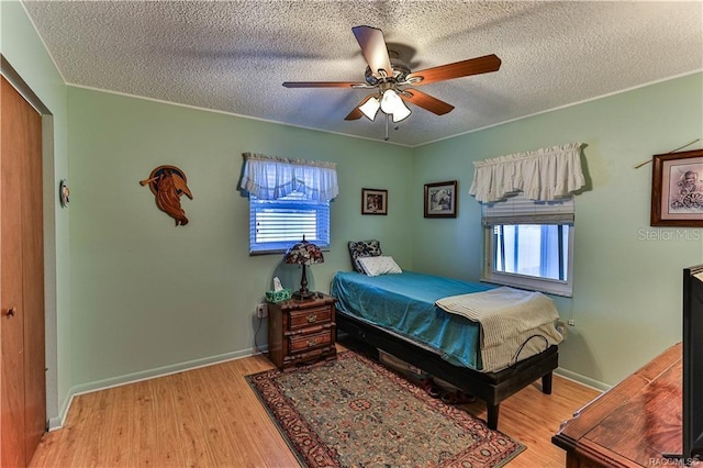 5626 W Justin Ct, Homosassa, FL 34448 - bedroom featuring multiple windows, wood finished floors, a textured ceiling, and ceiling fan