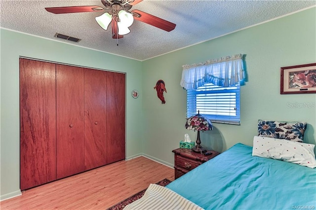 5626 W Justin Ct, Homosassa, FL 34448 - bedroom with a textured ceiling, wood finished floors, a closet, ceiling fan, and baseboards