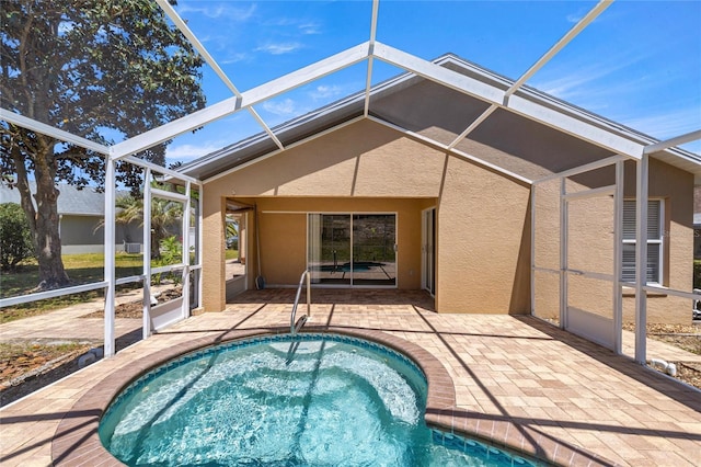 785 W Toucan Loop, Hernando, FL 34442 - rear view of house featuring a patio area, stucco siding, glass enclosure, and a hot tub