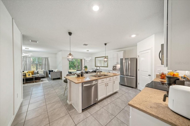 160 Hickory Course Loop, Ocala, FL 34472 - kitchen with appliances with stainless steel finishes, open floor plan, an island with sink, white cabinetry, and light tile patterned flooring