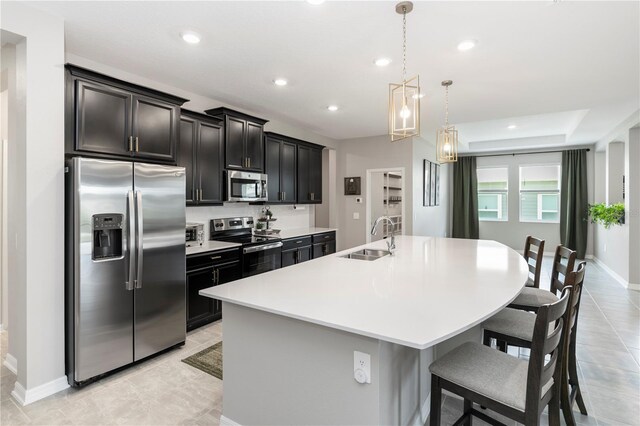 5248 Red Coral Cir, Mount Dora, FL 32757 - kitchen with appliances with stainless steel finishes, a sink, an island with sink, light countertops, and a breakfast bar area