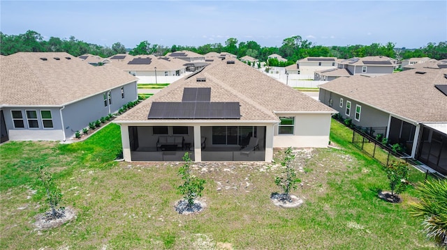 5248 Red Coral Cir, Mount Dora, FL 32757 - rear view of property featuring a sunroom, roof mounted solar panels, a residential view, and a shingled roof