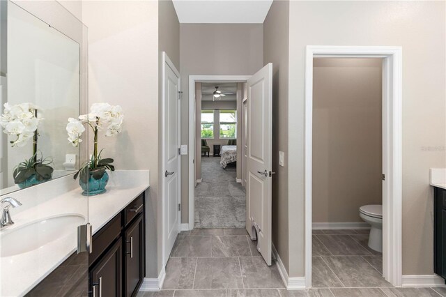 5248 Red Coral Cir, Mount Dora, FL 32757 - ensuite bathroom featuring vanity, a ceiling fan, toilet, and baseboards