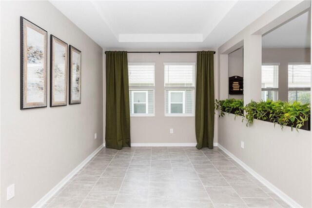 5248 Red Coral Cir, Mount Dora, FL 32757 - empty room featuring a raised ceiling, plenty of natural light, and baseboards