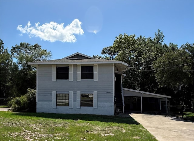 view of front of house featuring a front yard, a carport, concrete driveway, and brick siding