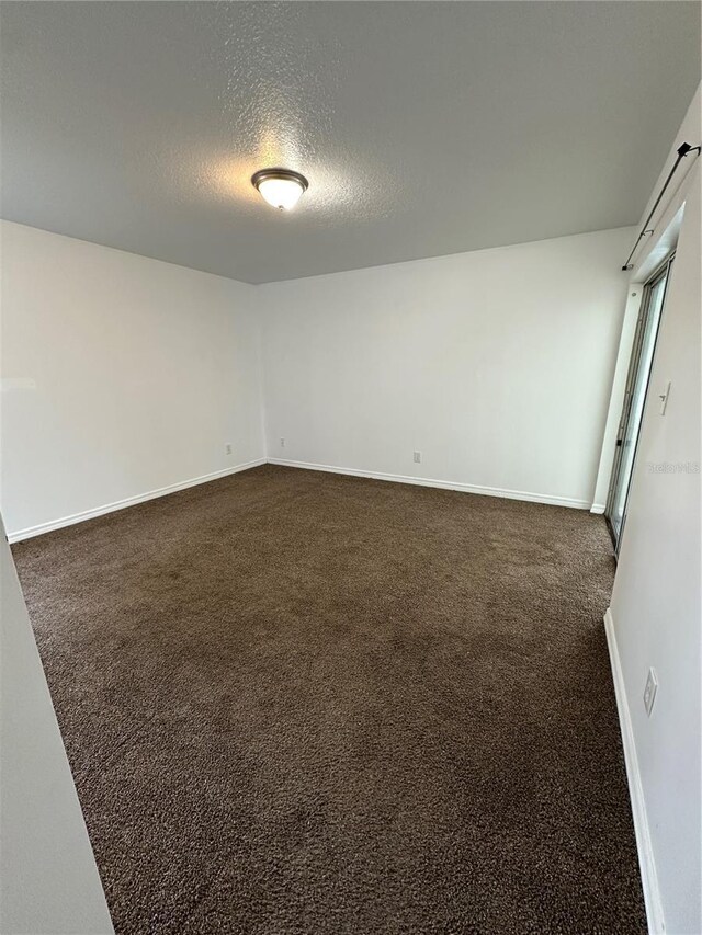 5525 SE 43rd Ct, Ocala, FL 34480 - spare room with a textured ceiling, dark carpet, and baseboards