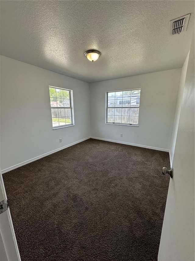 5525 SE 43rd Ct, Ocala, FL 34480 - empty room featuring a textured ceiling, dark carpet, and baseboards