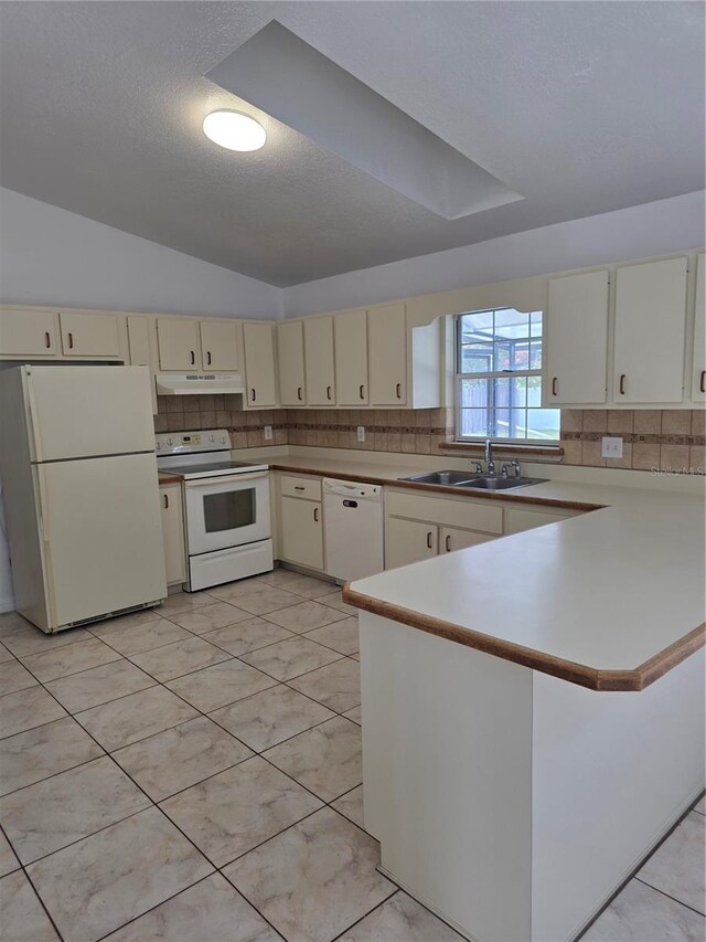 5525 SE 43rd Ct, Ocala, FL 34480 - kitchen with white appliances, a sink, cream cabinetry, under cabinet range hood, and lofted ceiling