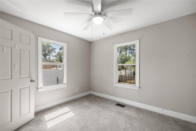 1014 NE 12th St, Ocala, FL 34470 - carpeted empty room with healthy amount of natural light, baseboards, and ceiling fan