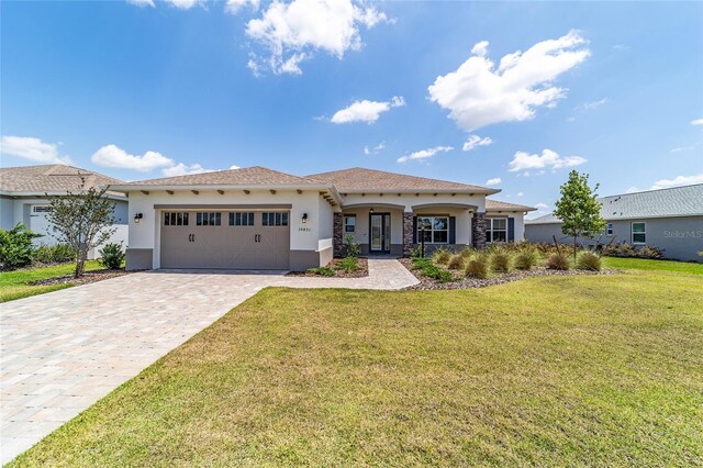 10451 SW 98th Place Rd, Ocala, FL 34481 - mediterranean / spanish-style house with stucco siding, a garage, a front lawn, and decorative driveway