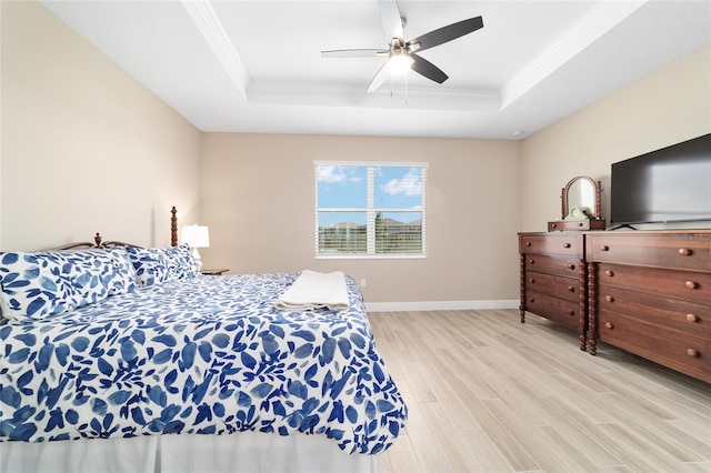 10451 SW 98th Place Rd, Ocala, FL 34481 - bedroom with a tray ceiling, light wood-style flooring, crown molding, baseboards, and a ceiling fan