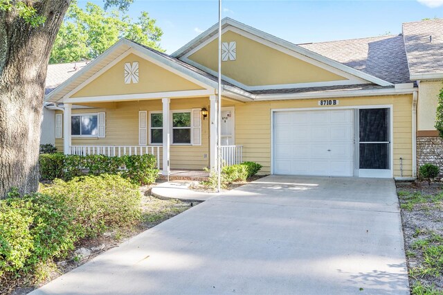 8710 SW 91st Pl Unit B, Ocala, FL 34481 - view of front of house with an attached garage, covered porch, concrete driveway, and roof with shingles