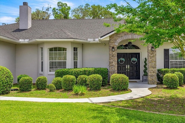 1107 SE 49th Ave, Ocala, FL 34471 - doorway to property with stucco siding, a lawn, a chimney, roof with shingles, and stone siding