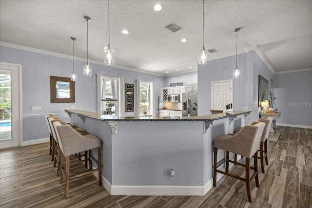 1107 SE 49th Ave, Ocala, FL 34471 - kitchen with stainless steel appliances, wood finished floors, healthy amount of natural light, crown molding, and a textured ceiling