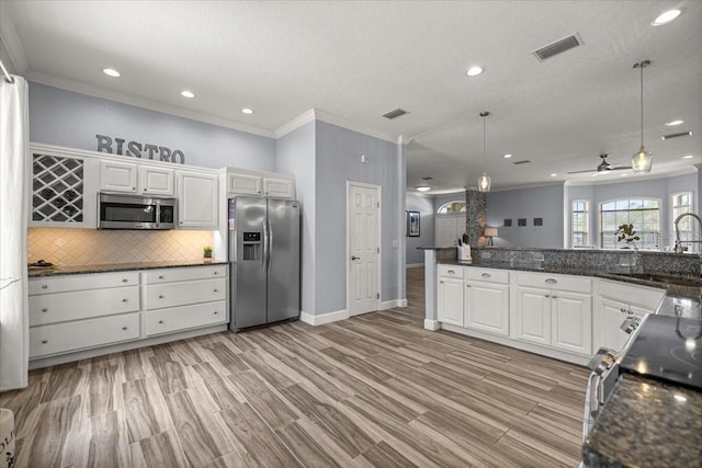 1107 SE 49th Ave, Ocala, FL 34471 - kitchen with appliances with stainless steel finishes, ornamental molding, decorative backsplash, a sink, and white cabinetry