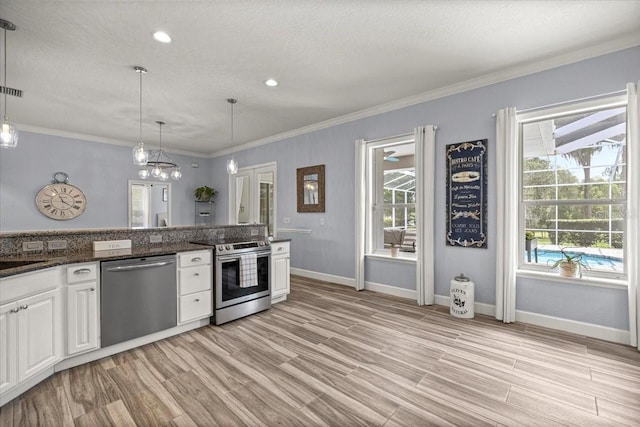 1107 SE 49th Ave, Ocala, FL 34471 - kitchen featuring stainless steel appliances, white cabinetry, light wood-style floors, baseboards, and ornamental molding