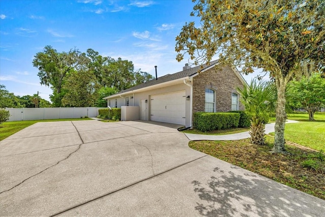1107 SE 49th Ave, Ocala, FL 34471 - view of home's exterior featuring an attached garage, concrete driveway, and a chimney