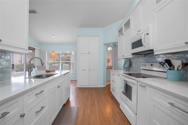 3656 E Lake Todd Dr, Hernando, FL 34442 - kitchen with white appliances, a sink, backsplash, light countertops, and white cabinets