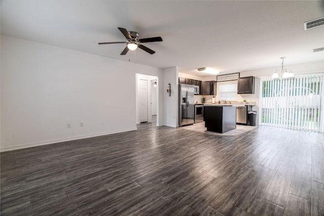 3897 SW 169th Lane Rd, Ocala, FL 34473 - unfurnished living room with a chandelier, wood finished floors, a ceiling fan, baseboards, and a sink