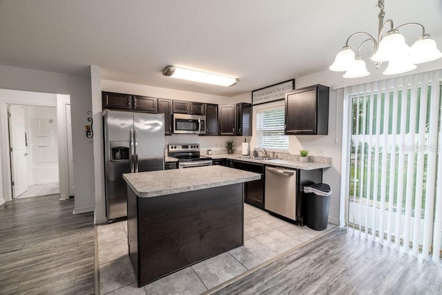 3897 SW 169th Lane Rd, Ocala, FL 34473 - kitchen featuring appliances with stainless steel finishes, a chandelier, dark brown cabinetry, a sink, and light countertops