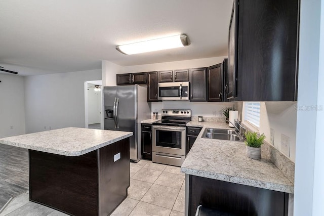 3897 SW 169th Lane Rd, Ocala, FL 34473 - kitchen featuring stainless steel appliances, a sink, light countertops, light tile patterned floors, and a kitchen island