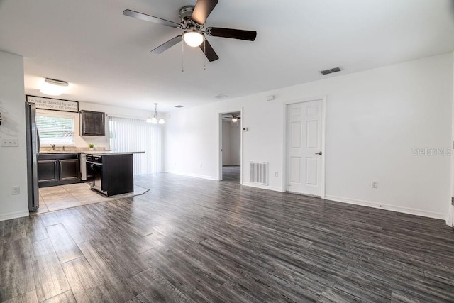 3897 SW 169th Lane Rd, Ocala, FL 34473 - unfurnished living room with ceiling fan, a chandelier, wood finished floors, and a sink