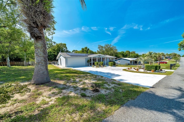 66 S Desoto St, Beverly Hills, FL 34465 - view of front of house featuring driveway, solar panels, and a garage