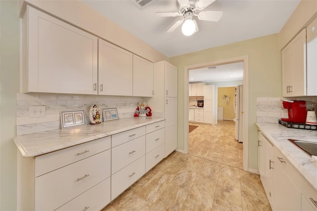 66 S Desoto St, Beverly Hills, FL 34465 - kitchen featuring freestanding refrigerator, tasteful backsplash, a ceiling fan, and white cabinets