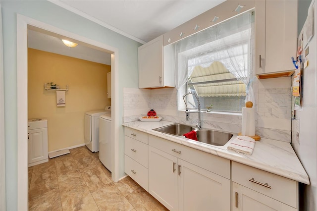66 S Desoto St, Beverly Hills, FL 34465 - kitchen featuring a sink, independent washer and dryer, light countertops, white cabinetry, and ornamental molding