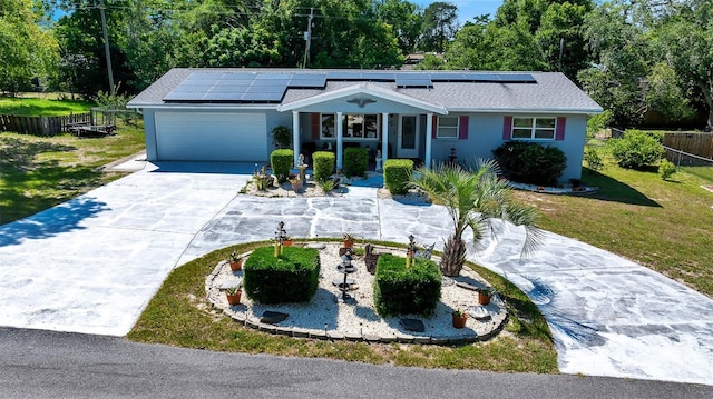 66 S Desoto St, Beverly Hills, FL 34465 - view of front of property featuring driveway, a garage, and roof mounted solar panels