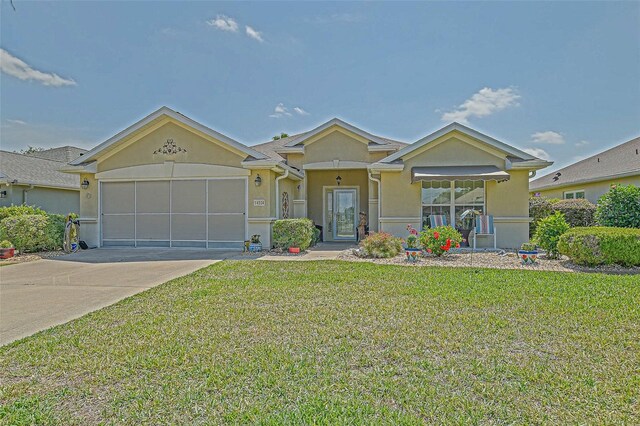 14004 SE 94th Ave, Summerfield, FL 34491 - view of front of house featuring stucco siding, a front lawn, concrete driveway, and an attached garage