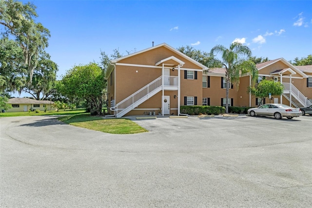 4450 E Windmill Dr Unit 101, Inverness, FL 34453 - view of property featuring stairway and uncovered parking