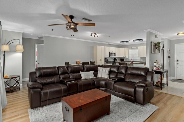 4450 E Windmill Dr Unit 101, Inverness, FL 34453 - living area featuring ornamental molding, a ceiling fan, light wood-style floors, and baseboards