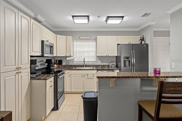 4450 E Windmill Dr Unit 101, Inverness, FL 34453 - kitchen featuring appliances with stainless steel finishes, a sink, a breakfast bar area, ornamental molding, and dark stone counters