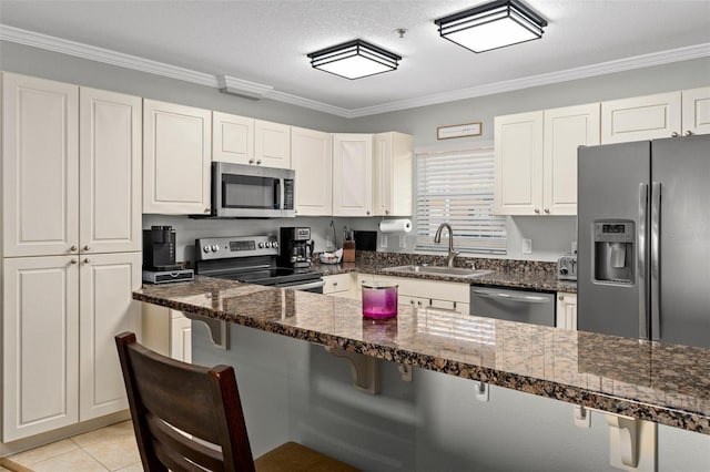 4450 E Windmill Dr Unit 101, Inverness, FL 34453 - kitchen featuring stainless steel appliances, a sink, a kitchen breakfast bar, white cabinets, and crown molding
