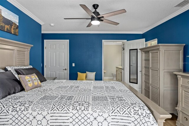 4450 E Windmill Dr Unit 101, Inverness, FL 34453 - bedroom featuring crown molding, a textured ceiling, ceiling fan, and ensuite bathroom