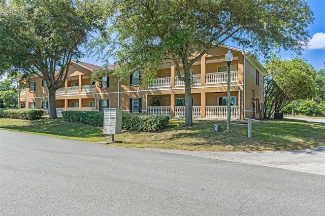 4450 E Windmill Dr Unit 101, Inverness, FL 34453 - view of property featuring stucco siding, a front yard, and a balcony