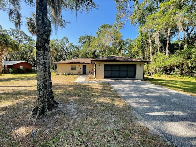 9740 W Cranberry St, Crystal River, FL 34428 - view of front facade featuring a garage, asphalt driveway, stucco siding, and a front yard