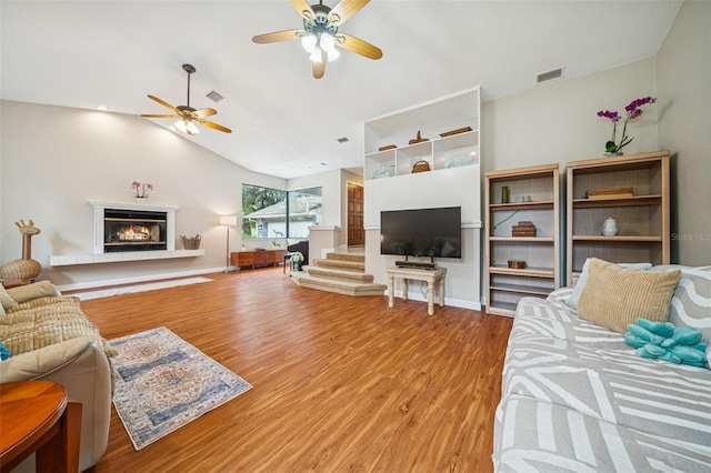 451 E Ireland Ct, Hernando, FL 34442 - living room with ceiling fan, wood finished floors, a glass covered fireplace, lofted ceiling, and baseboards