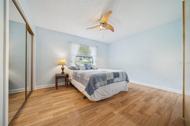 451 E Ireland Ct, Hernando, FL 34442 - bedroom with light wood finished floors, a closet, baseboards, ceiling fan, and a textured ceiling