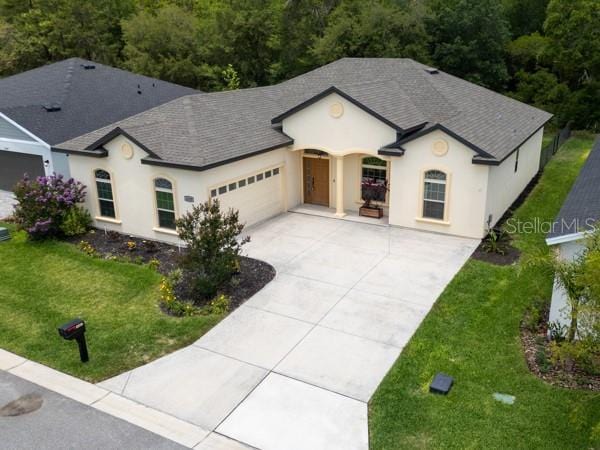 6235 SW 95th Pl, Ocala, FL 34476 - french provincial home featuring a garage, concrete driveway, stucco siding, and a front yard