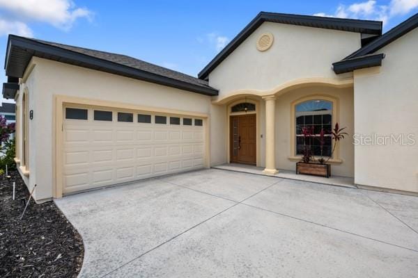 6235 SW 95th Pl, Ocala, FL 34476 - view of front of house featuring stucco siding, an attached garage, and driveway