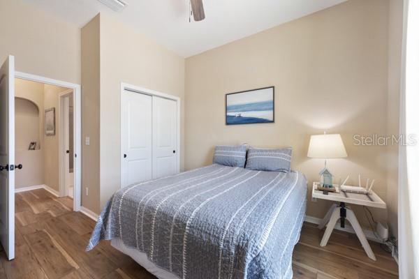 6235 SW 95th Pl, Ocala, FL 34476 - bedroom with wood finished floors, a closet, baseboards, and ceiling fan